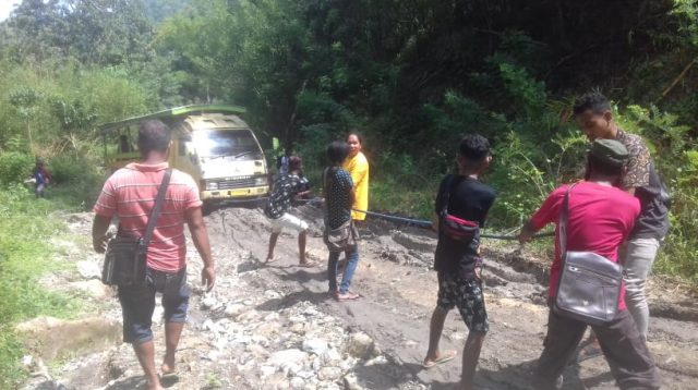 Warga menarik kendaraan yang mereka tumpangi dengan tambang karena tidak bisa melintasi jalan berlumpur (foto: Fidel D)