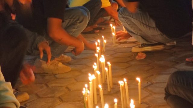 Aksi Damai yang ditutup dengan menyalakan lilin mengenang mendiang Roy Bolle